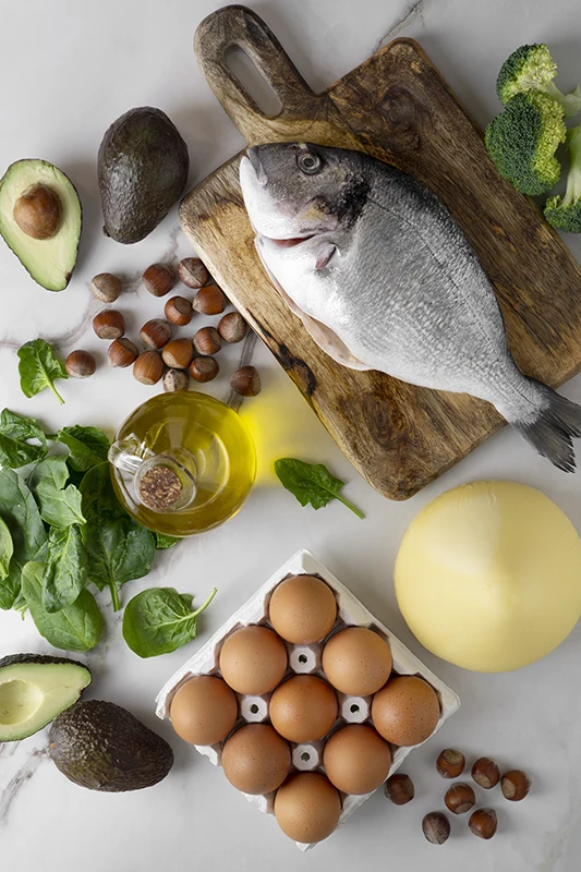 Vue de dessus d’un assortiment d’aliments riches en vitamines B : œufs, saumon, épinards, avocat, noix et céréales complètes – pour des gencives saines | Dental Geneva